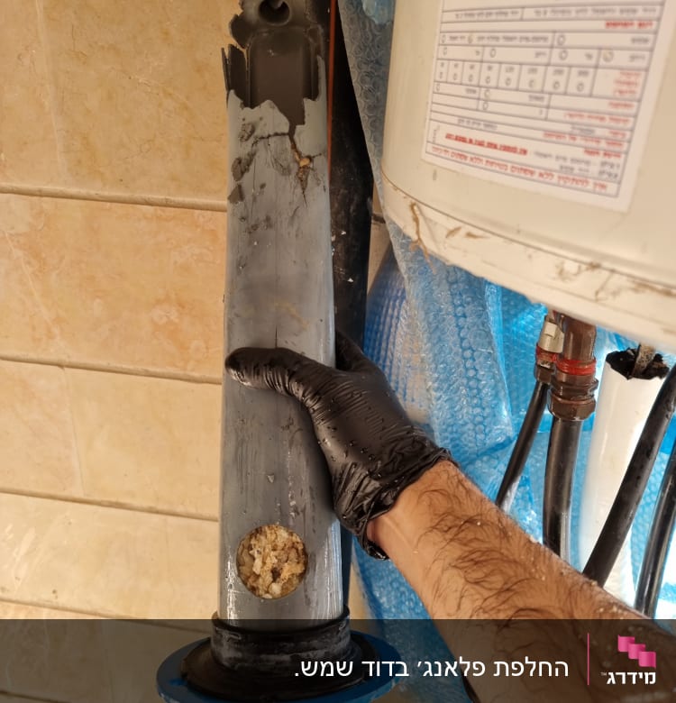 יד עם כפפה מחזיקה חלק מבודד של דוד שמש